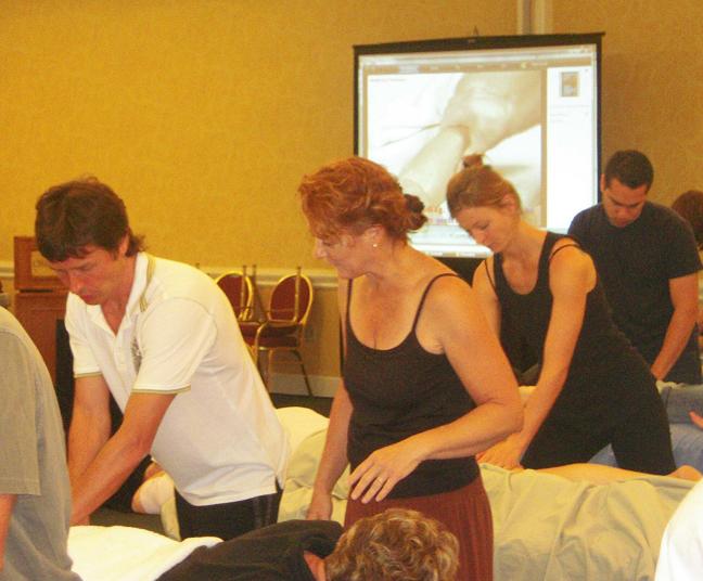 O. Bouimer individually trains a student in Sports Massage techniques while the video of each technique played on the screen